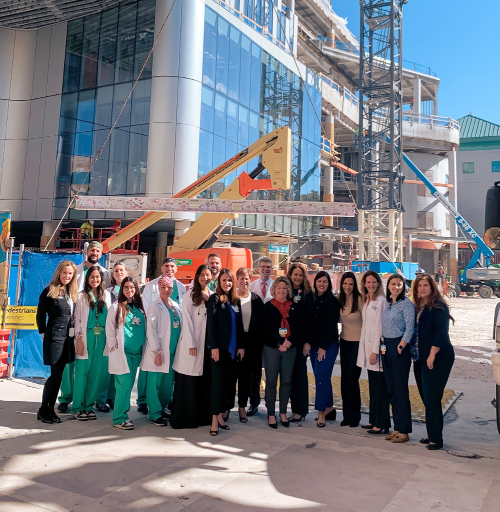 Physician team members in front of construction of the Kenneth C. Griffin Surgical Tower