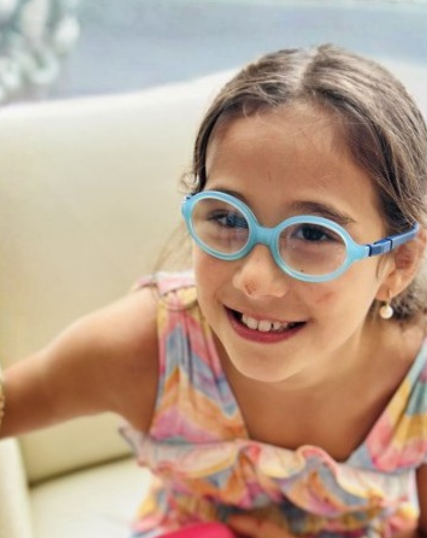 Victoria smiling wearing blue glasses
