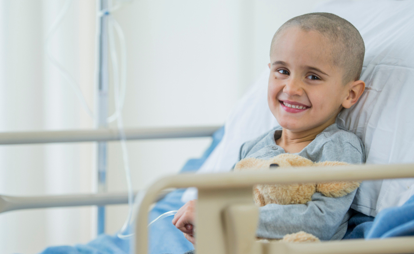 A patient with a teddy bear in a hospital bed
