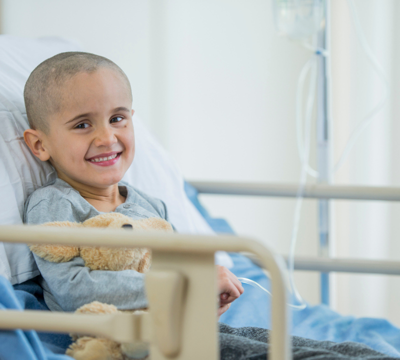 A patient with a teddy bear in a hospital bed