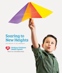 Child holding a colorful paper airplane